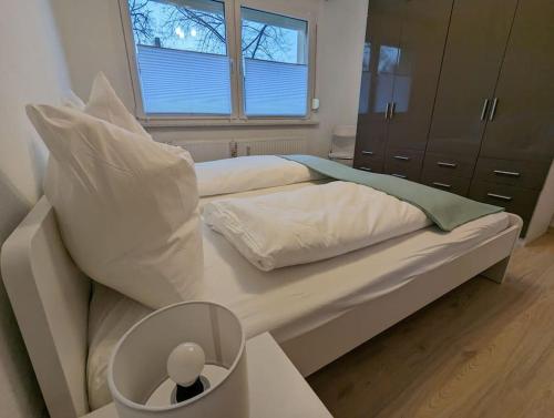 a bed with white sheets and pillows and a window at Ferienwohnung Elbaue in Barby