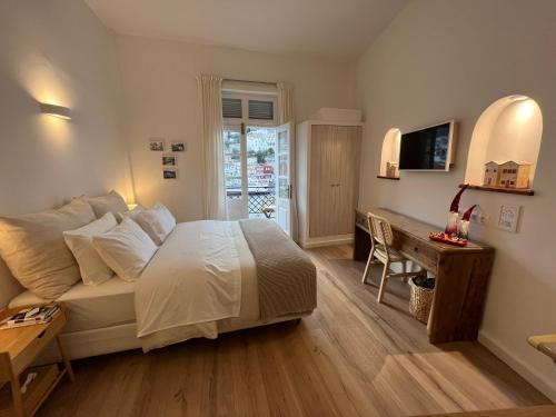 a bedroom with a bed and a table and a desk at Estia Hydra in Hydra