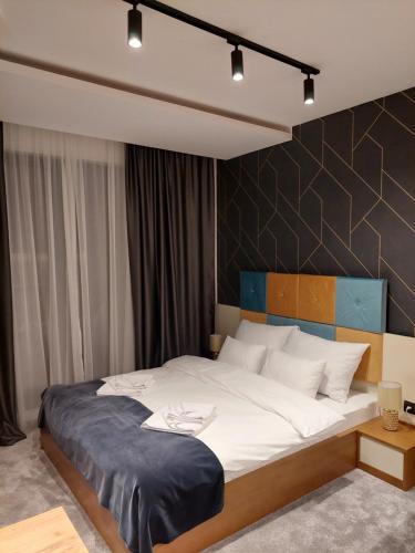 Un dormitorio con una cama grande con una manta azul. en Nela apartmani (u hotelu Djina), en Kopaonik