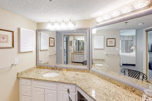 a bathroom with two sinks and a large mirror at Inlet Reef in Destin