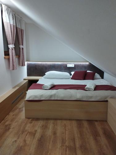 ein Schlafzimmer mit einem großen Bett mit roten Kissen in der Unterkunft Apartmán Eliška Drevený raj in Spišská Nová Ves