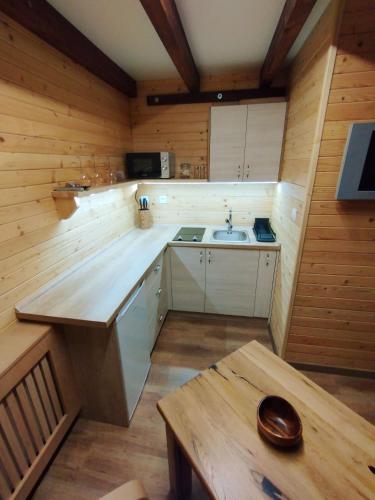 a small kitchen with a sink and a table at Apartmán Eliška Drevený raj in Spišská Nová Ves