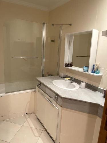 a bathroom with a sink and a shower and a mirror at Joli logement in Casablanca
