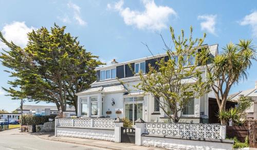 ein weißes Haus mit einem Zaun davor in der Unterkunft Alderberry Lodge in Newquay