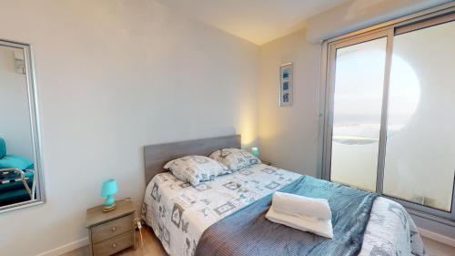 1 dormitorio con cama y ventana grande en Appart Le Concorde en Saint-Gilles-Croix-de-Vie