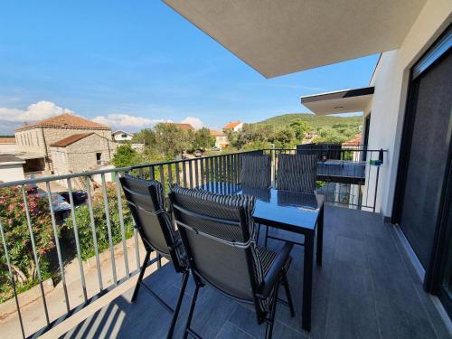 a balcony with a table and chairs on a balcony at Apartmani Nerium in Lovište