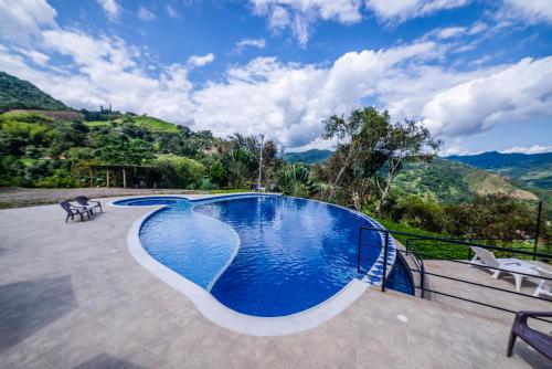 ein Schwimmbad mit Bergen im Hintergrund in der Unterkunft Tambo Eco Hotel in La Vega