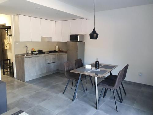 a kitchen with a table and chairs in a room at Apartmani Nerium in Lovište