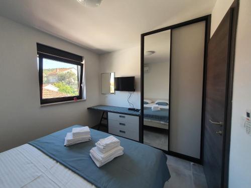 a bedroom with a mirror and a bed with towels at Apartmani Nerium in Lovište