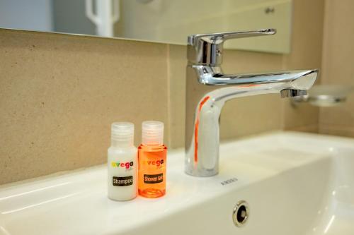 two bottles ofodorizers sitting on a bathroom sink at Avega Urban - Colombo 07 in Colombo