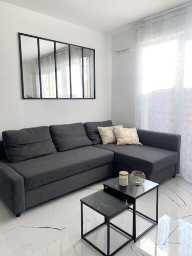 un salon avec un canapé et une table dans l'établissement Grand F3 à 30mn de Paris - Terrasse + Parking privé, à Saint-Ouen-lʼAumône