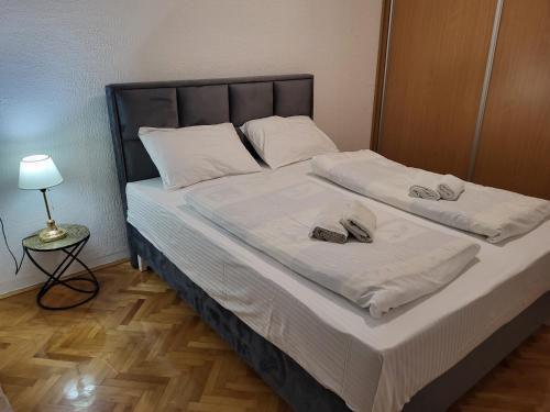 ein Schlafzimmer mit einem Bett mit zwei Hausschuhen darauf in der Unterkunft Apartman Andjela in Tivat