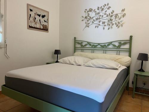 a bedroom with a bed with white sheets and two lamps at Le Noisetier in Cavalaire-sur-Mer