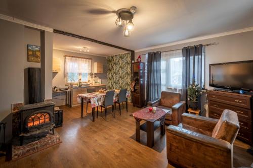 a living room with a fireplace and a table at Domek bez zegara in Lądek-Zdrój