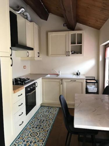 a kitchen with white cabinets and a table with chairs at Casa Sissi in Loreto