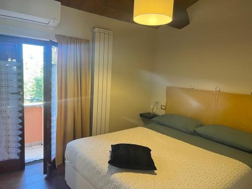 Un dormitorio con una cama con una bolsa negra. en Appartamento incantevole sull'antica via Lauretana, en Loreto