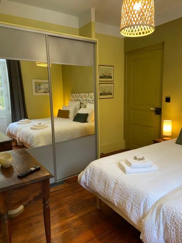 a room with two beds and a mirror at LE CLOS DU TULIPIER in La Chapelle-du-Bard