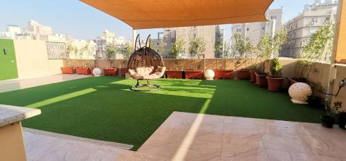 een balkon met een groene vloer en een stoel. bij shehab - residence Hotel apartment in Caïro