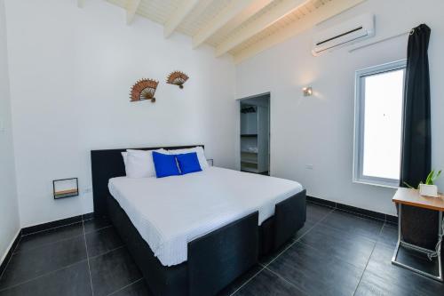 1 dormitorio con 1 cama grande con almohadas azules en A Serene Retreat with Modern Amenities, en Santa Cruz