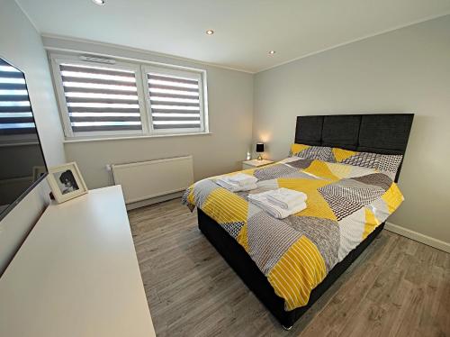 a bedroom with a bed and two windows at Private Room in Exclusive Apartment in Aberdeen