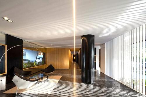 a lobby of a building with a table and chairs at Stylish Apartment by River with Pool & Grill in Olivos