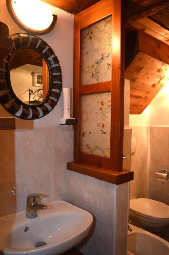 a bathroom with a sink and a mirror and a toilet at Casa della Nonna in Antronapiana