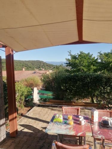 a patio with a table and chairs and a view at Maison de vacances dans les hauteurs de Salavas in Salavas