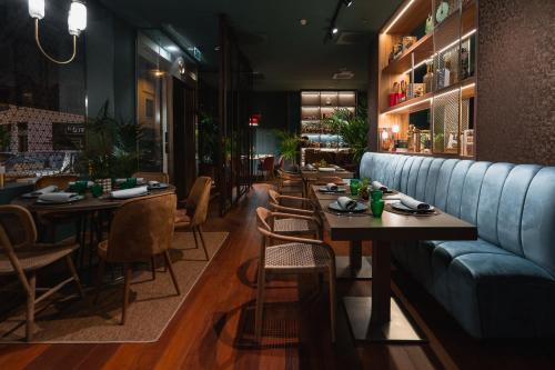 a restaurant with a blue couch and tables and chairs at Hotel Taburiente S.C.Tenerife in Santa Cruz de Tenerife