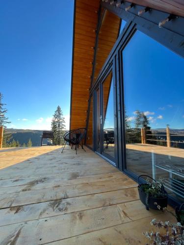 a deck with a bench and large glass windows at La KOLTAU A-Frame in Mărişel