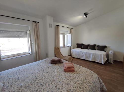 - une chambre avec 2 lits et une grande fenêtre dans l'établissement Casa Cerro Luna, à Constantina