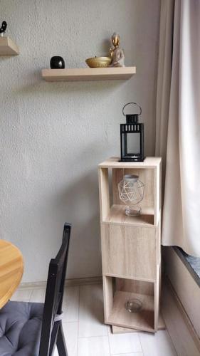 a table with a shelf and a chair in a room at Zen'Ny in Hotton