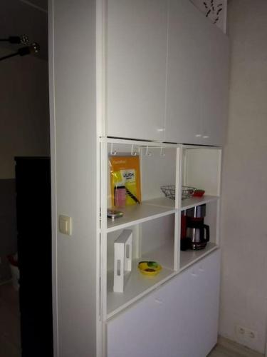 a white book shelf in a room with a coffee maker at Zen'Ny in Hotton