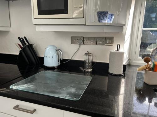 a kitchen with a counter top with a microwave at Beautiful Cottage near Harlech with ocean views in Llanfair