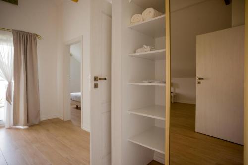 a room with a closet with white shelves and a door at Dwór i Dworek Leszczowate Wellness & Spa in Ustrzyki Dolne