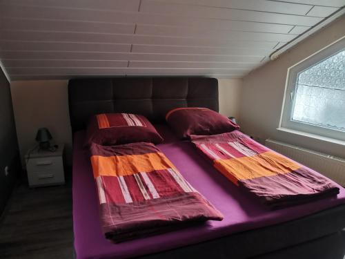 a bed with colorful blankets and pillows in a room at Ferienwohnung Schmidt Werratal in Wanfried