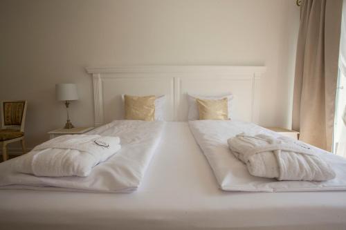 a large white bed with two towels on it at Dwór i Dworek Leszczowate Wellness & Spa in Ustrzyki Dolne