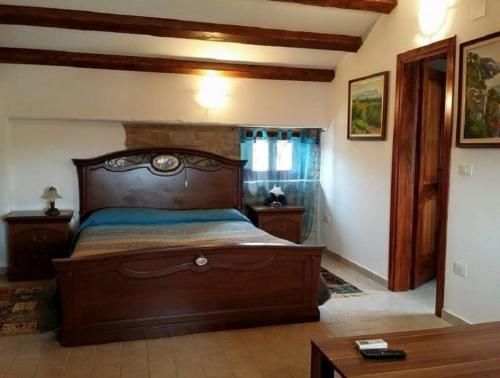 1 dormitorio con 1 cama grande de madera en una habitación en al Merlo Olivo, rural istrian house, en Buje