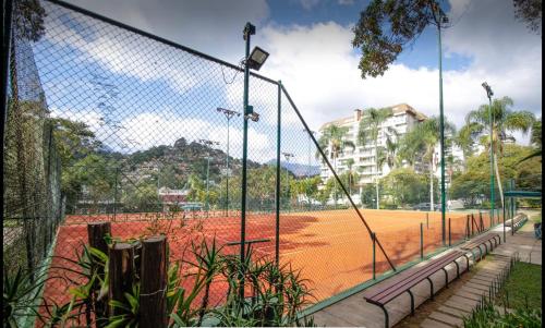 a tennis court with a net on a tennis court at Flat Completo Granja Brasil in Petrópolis