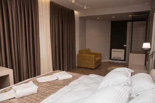 a bedroom with a bed with two towels on it at Vila Muslli in Korçë