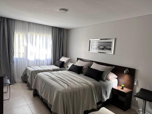 Habitación de hotel con 2 camas y ventana en Suite del sol en Pinamar