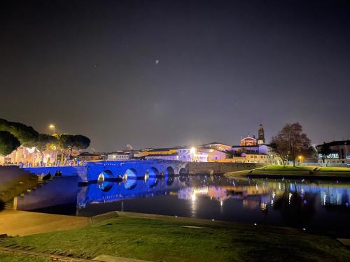 a blue bridge over a river at night at Hotel Villa del Parco in Rimini