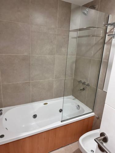 y baño con bañera y aseo. en Suite del sol en Pinamar