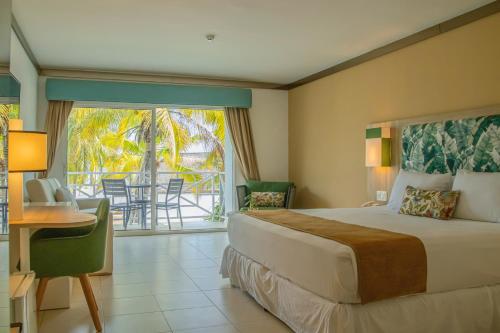 Habitación de hotel con cama y balcón en Playa Blanca Beach Resort - All Inclusive en Playa Blanca