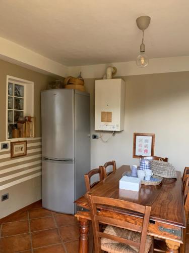 eine Küche mit einem Tisch und einem Kühlschrank aus Edelstahl in der Unterkunft Il Riccio appartamento in Cernobbio