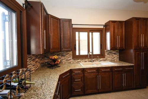 una cocina con armarios de madera y fregadero en Vlihadia Bay Luxury Villa, en Kalymnos