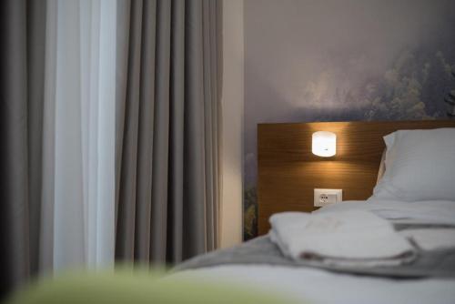 a bedroom with a bed with a light on it at Vila Muslli in Korçë