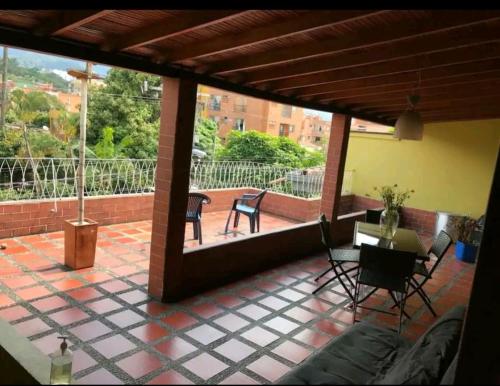 balcón con mesa y sillas en el patio en Alcobas con desayuno incluido baño compartido, en Medellín