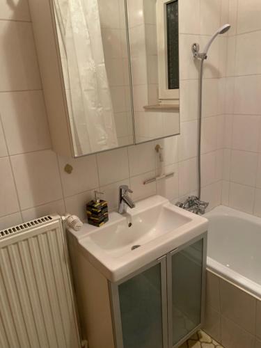 ein Badezimmer mit einem Waschbecken, einem Spiegel und einer Badewanne in der Unterkunft FeWo an der Weser in Nordenham