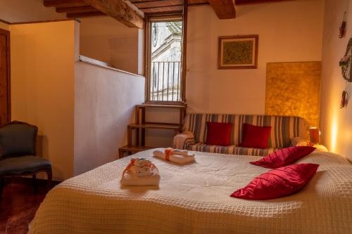 a bedroom with a bed with red pillows and a window at La Torre del Conte,Free Wi-fi, Amazing view in Montepulciano