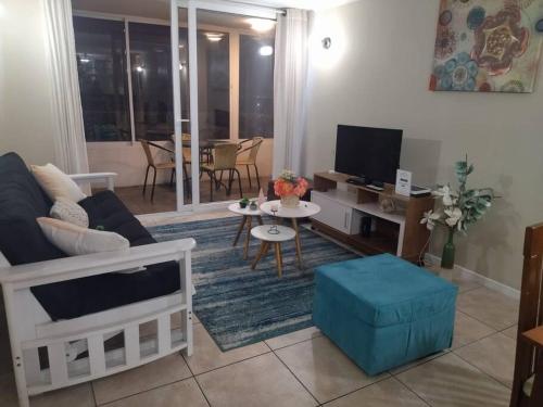 a living room with a couch and a tv at Depto. frente a la playa con hermosa vista al mar y faro La Serena in La Serena